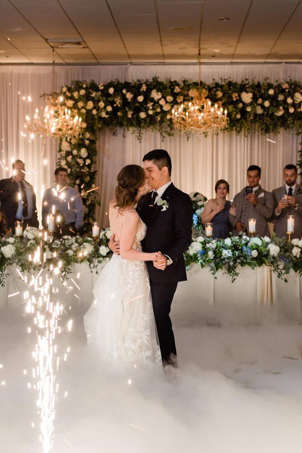 An enchanting bride and groom gracefully dance, surrounded by twinkling sparklers, while being serenaded by skilled Chicago DJs.