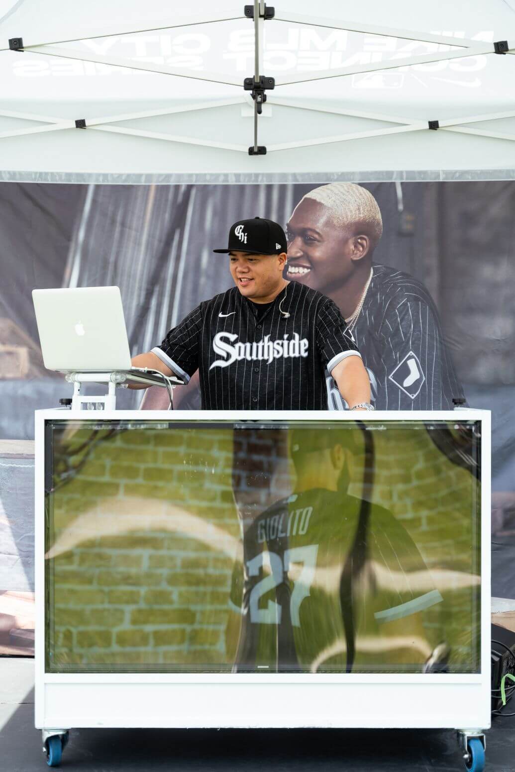 A man sitting at a table with a laptop, working as a DJ in Chicago.