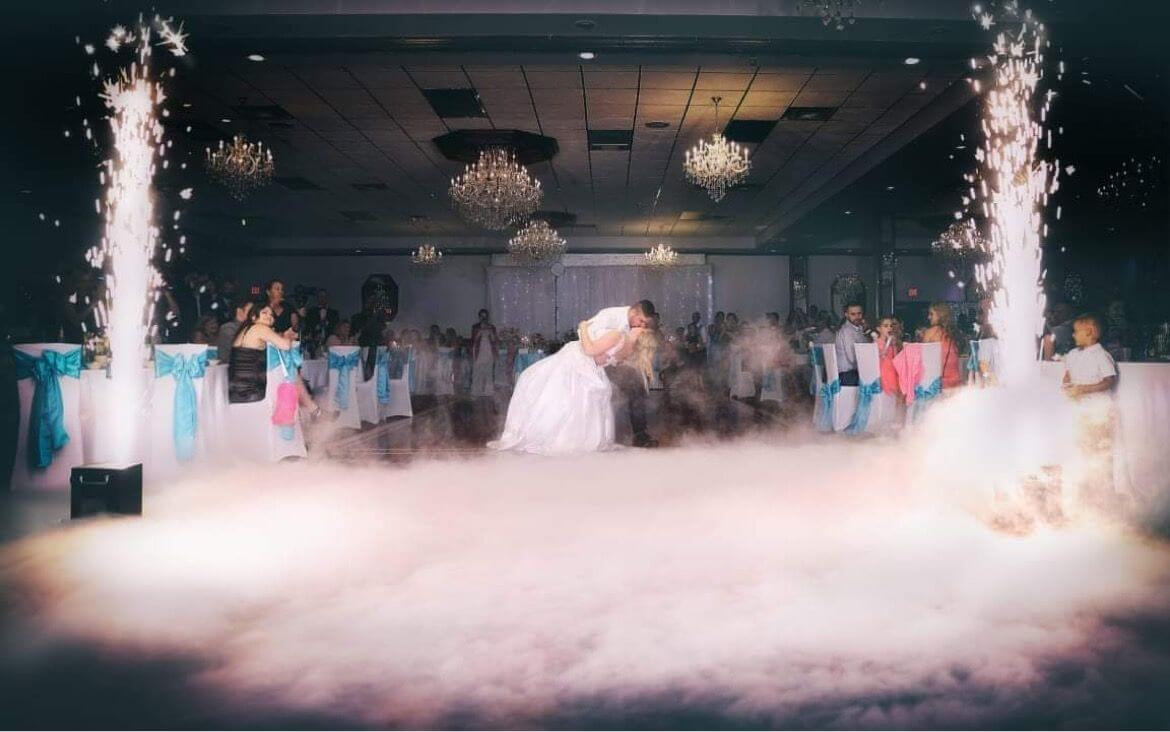 A wedding couple standing in front of a cloud of smoke as Chicago wedding DJs set the perfect ambiance for their celebration.