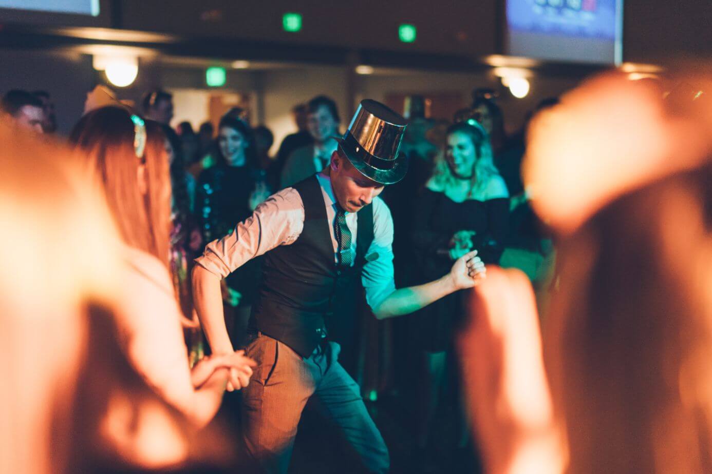 A Chicago DJ in a top hat dancing at a party.