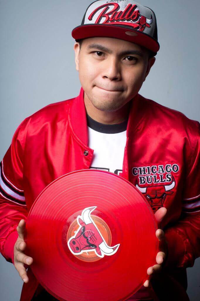 A man holding up a red Chicago Bulls record in Chicago, IL.