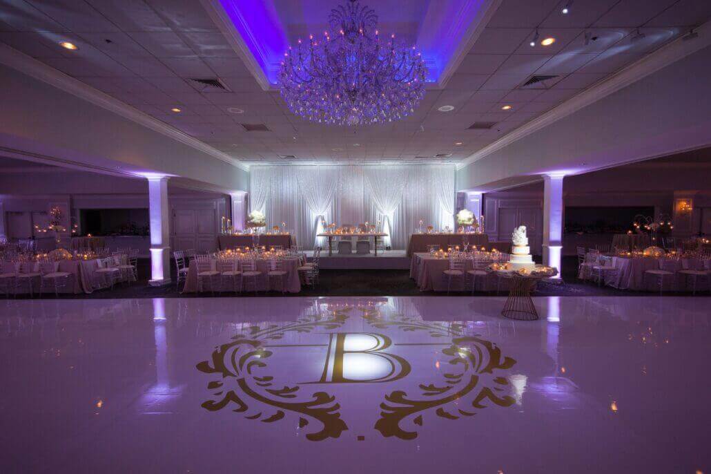 purple wedding reception and white dance floor with 'B' gold monogram The Empress Banquets